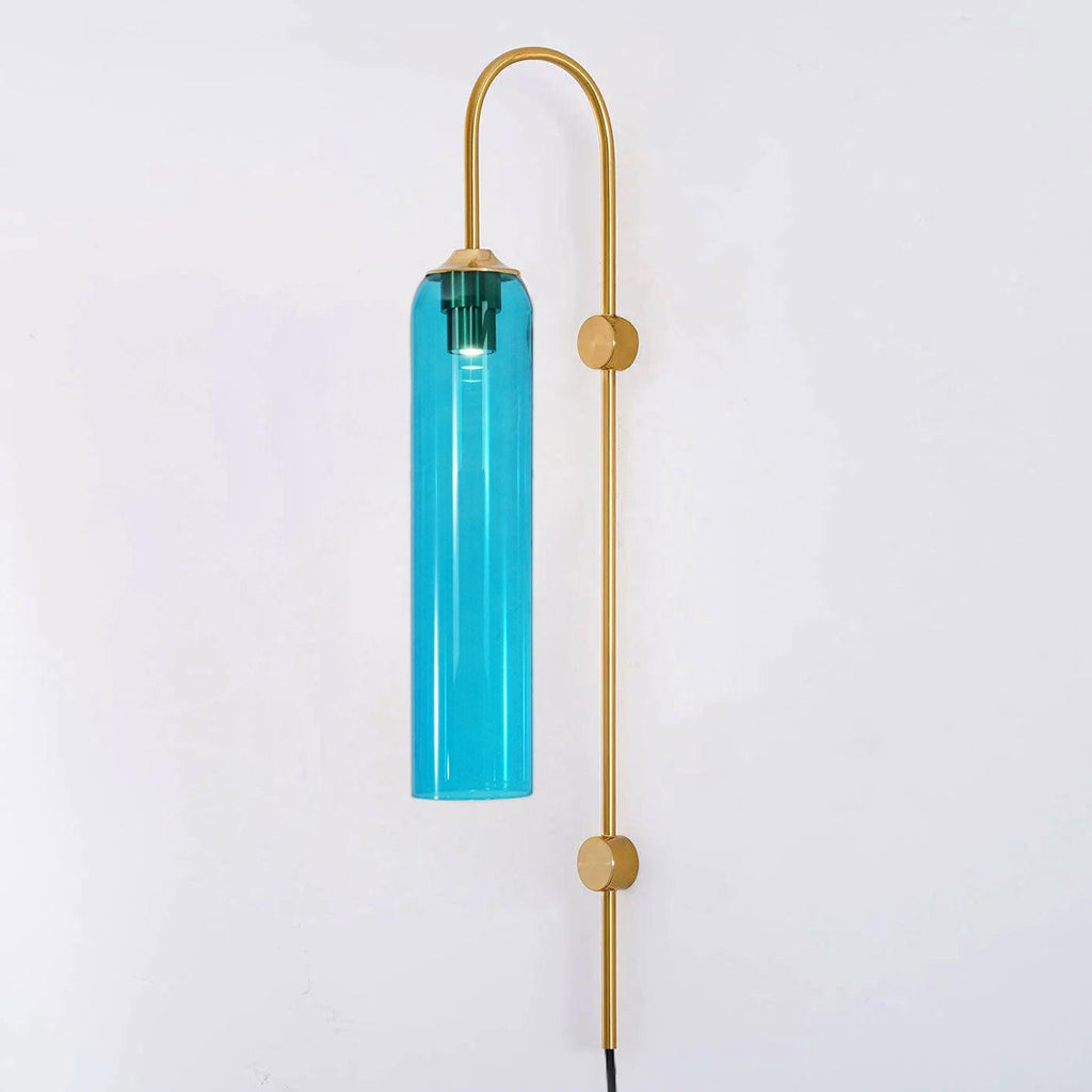 Sky blue glass on the Clérachic mouth-blown wall sconce with a gold body, lit and photographed against a plain white wall.