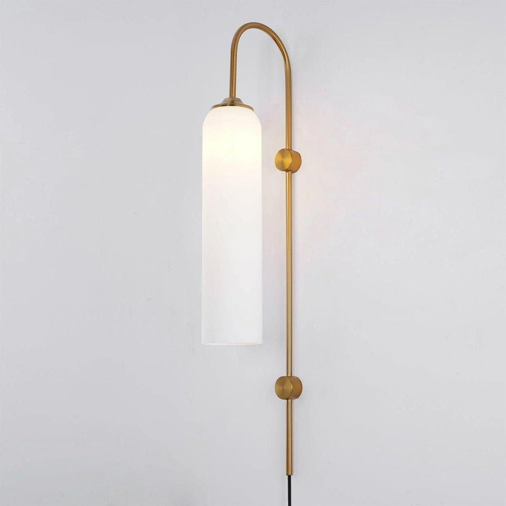 Frosted white glass on the Clérachic mouth-blown wall sconce in gold, softening the bulb to a broad band of light.