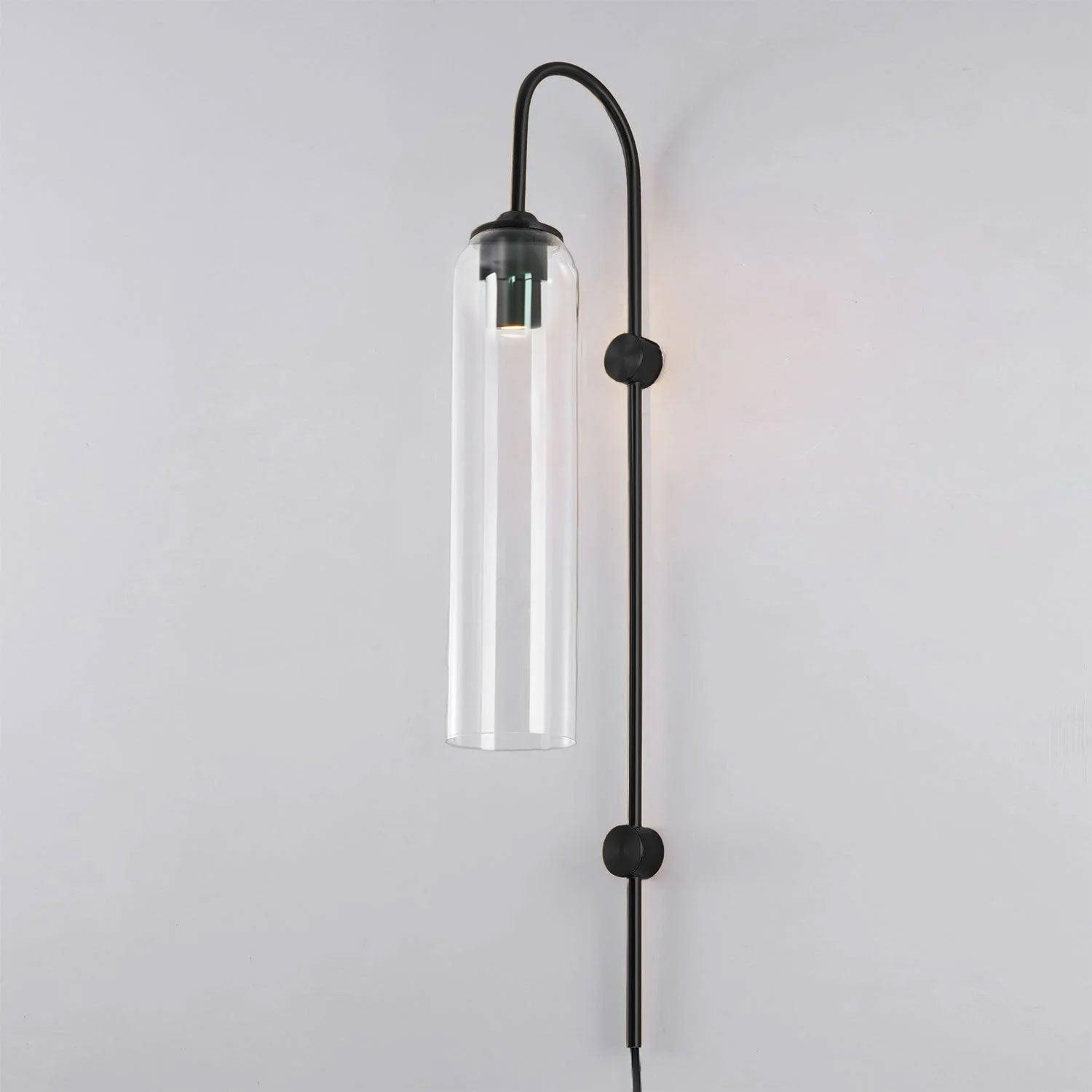 Clear glass on the Clérachic mouth-blown wall sconce with a black body, the metal sleeve visible at the top of the cylinder.
