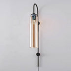 Amber glass paired with the black body of the Clérachic mouth-blown wall sconce, a warm reflection running down the glass.