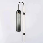 Smoke grey glass on the black Clérachic mouth-blown wall sconce, light pooling at the top where the bulb sits.