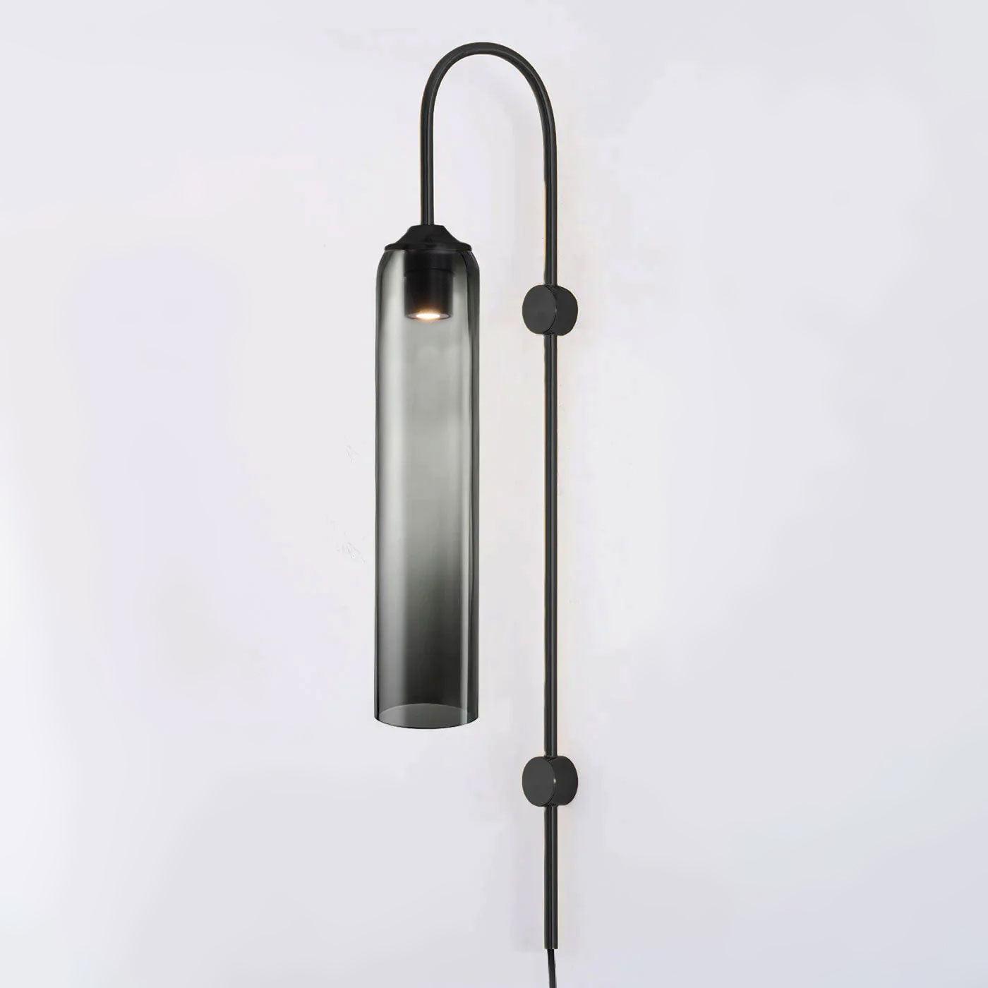 Smoke grey glass on the black Clérachic mouth-blown wall sconce, light pooling at the top where the bulb sits.