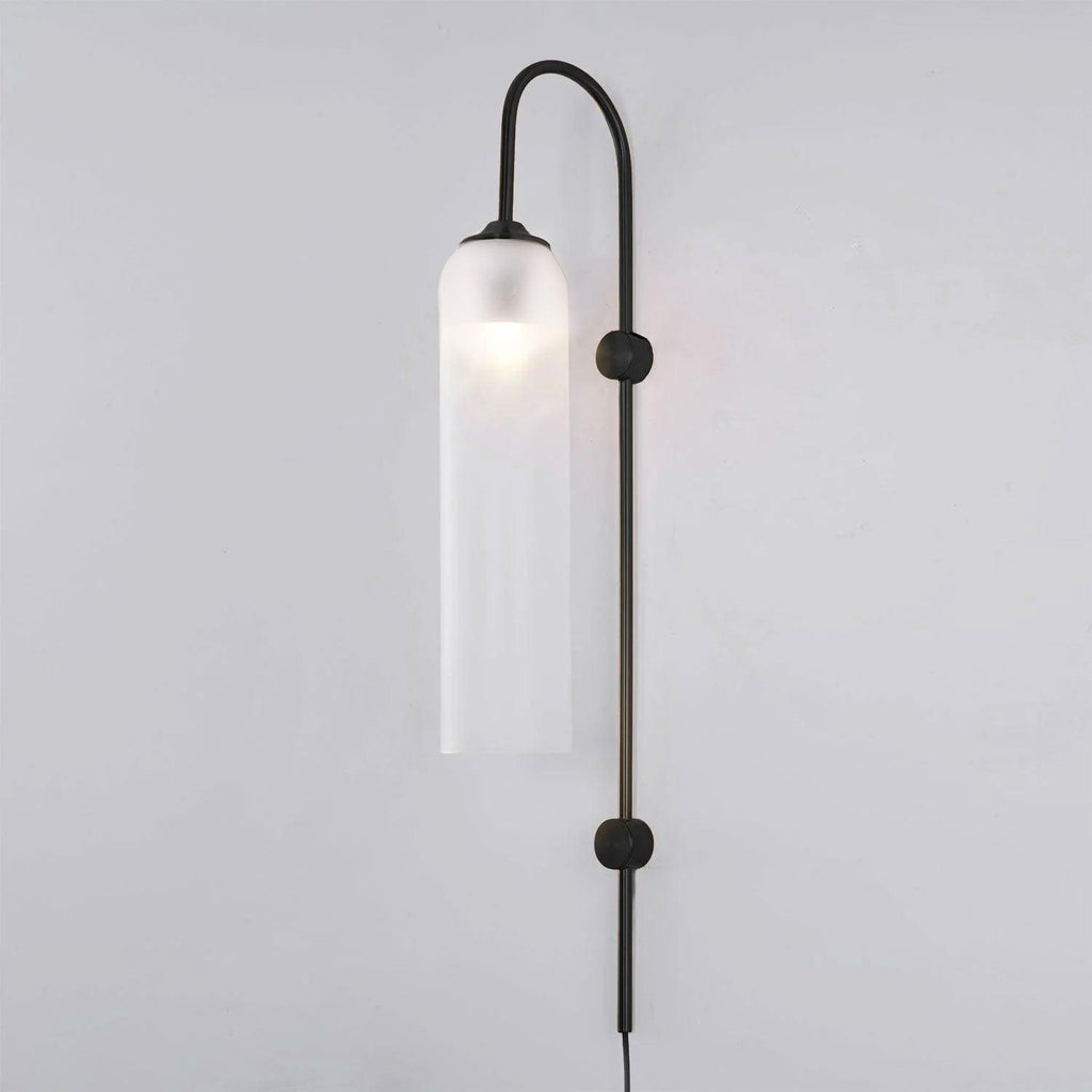 Frosted white glass on the black Clérachic mouth-blown wall sconce, the bulb showing as a soft bright spot near the top.