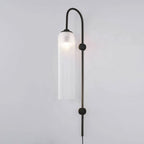 Frosted white glass on the black Clérachic mouth-blown wall sconce, the bulb showing as a soft bright spot near the top.