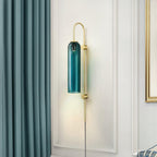 Clérachic mouth-blown glass wall sconce in teal on a white panelled wall, between a teal curtain and a gold-framed mirror.