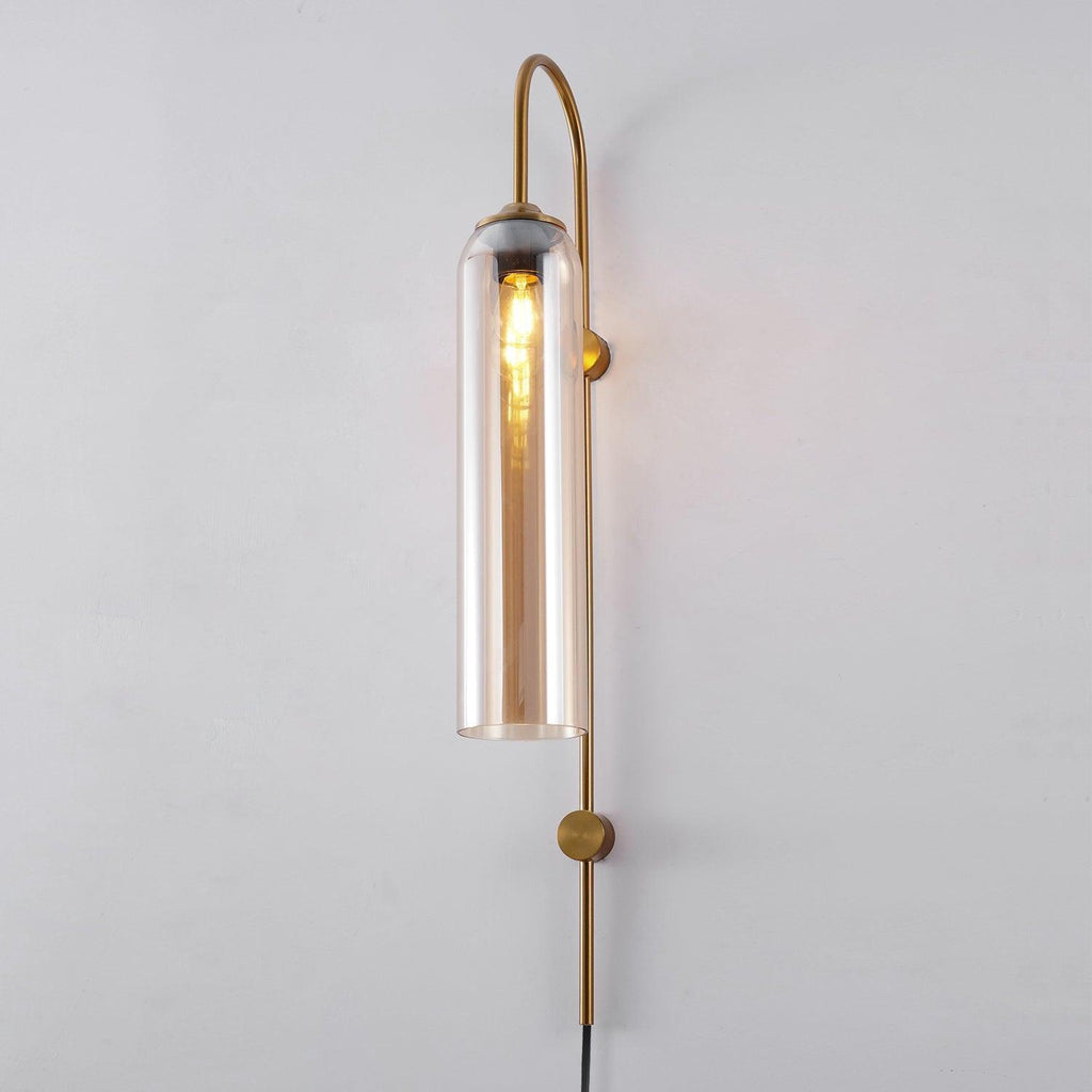 Clérachic mouth-blown glass wall sconce in amber glass on gold, the long filament bulb reading clearly through the cylinder.