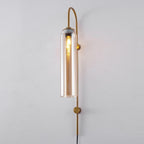 Clérachic mouth-blown glass wall sconce in amber glass on gold, the long filament bulb reading clearly through the cylinder.