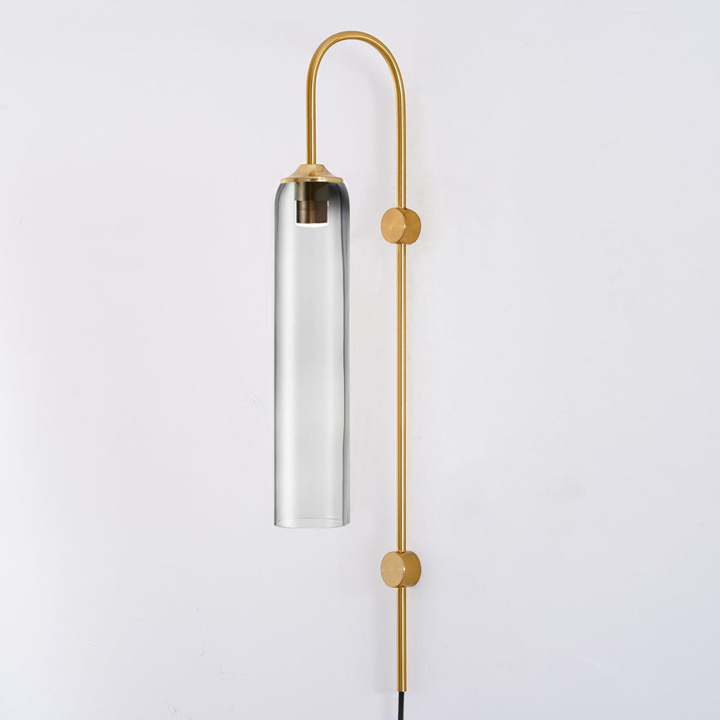 Clérachic mouth-blown glass wall sconce in smoke grey on gold, the metal bulb sleeve just visible through the pale glass.