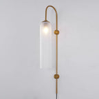 Clérachic mouth-blown glass wall sconce in frosted white on gold, the bulb blooming as a soft halo near the top.