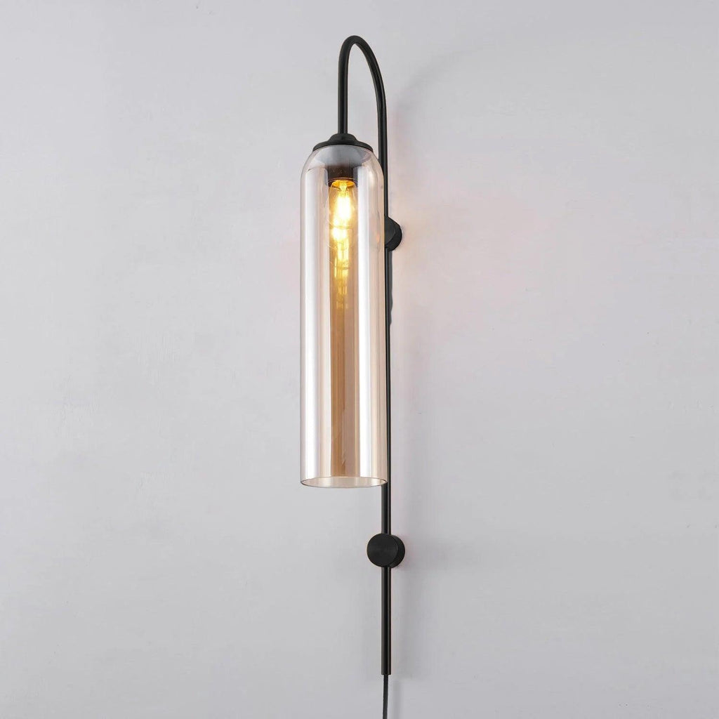 Clérachic mouth-blown glass wall sconce in amber on black, the filament running most of the length of the cylinder.