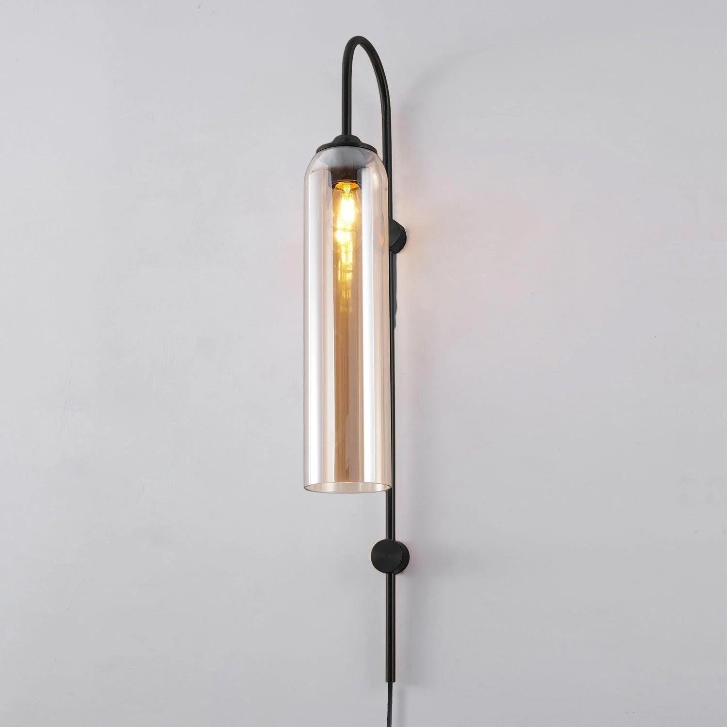 Clérachic mouth-blown glass wall sconce in amber on black, the filament running most of the length of the cylinder.