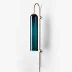 Clérachic mouth-blown glass wall sconce in teal seen three-quarter on, the bulb holder visible at the cap of the shade.