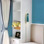 Clérachic mouth-blown glass wall sconce in teal in a blue bedroom, mounted between white shelving and the headboard.
