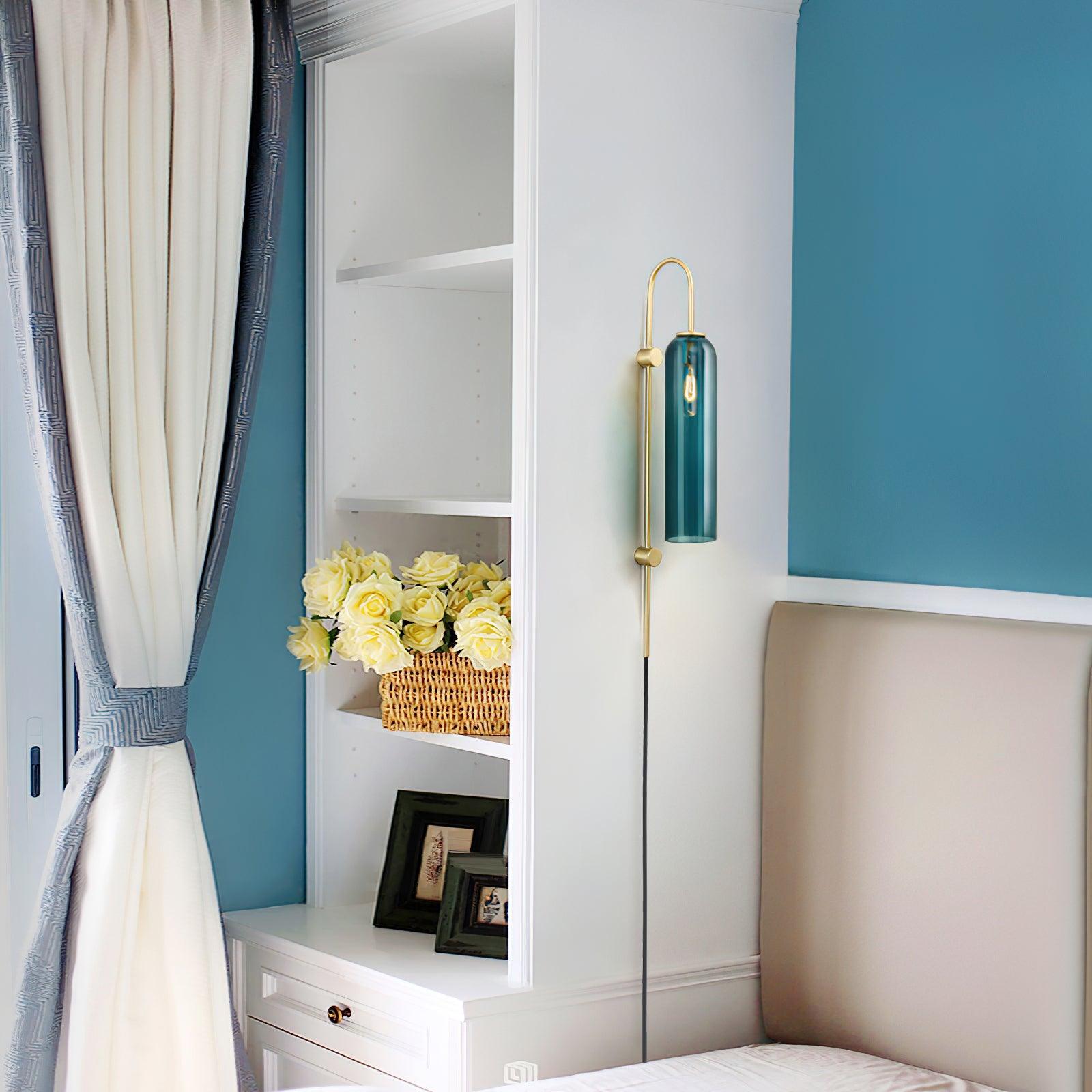 Clérachic mouth-blown glass wall sconce in teal in a blue bedroom, mounted between white shelving and the headboard.