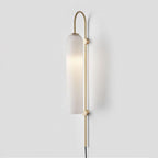 Clérachic mouth-blown glass wall sconce in frosted white on brushed gold, lit softly and casting a wide wall shadow.