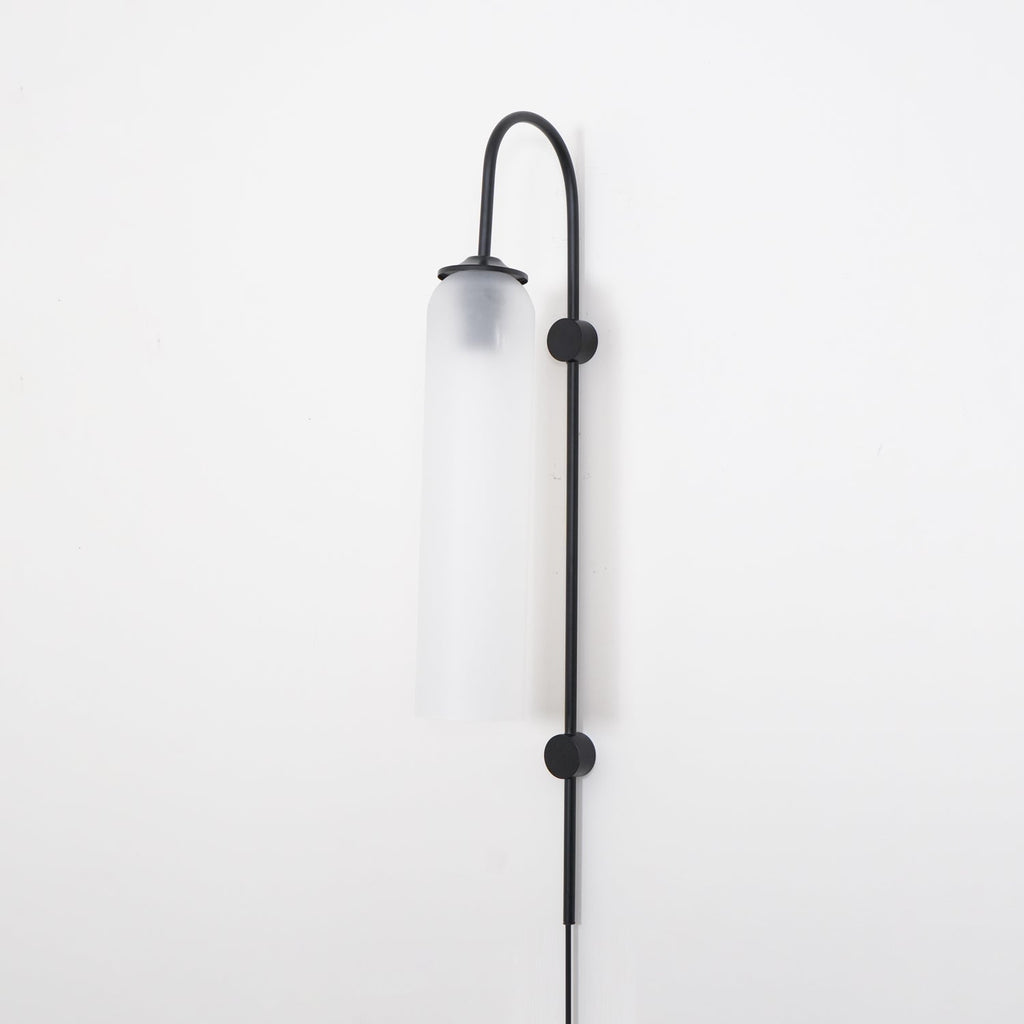 Clérachic mouth-blown glass wall sconce in frosted white on black, unlit, both disc mounts fixing the rod to the wall.