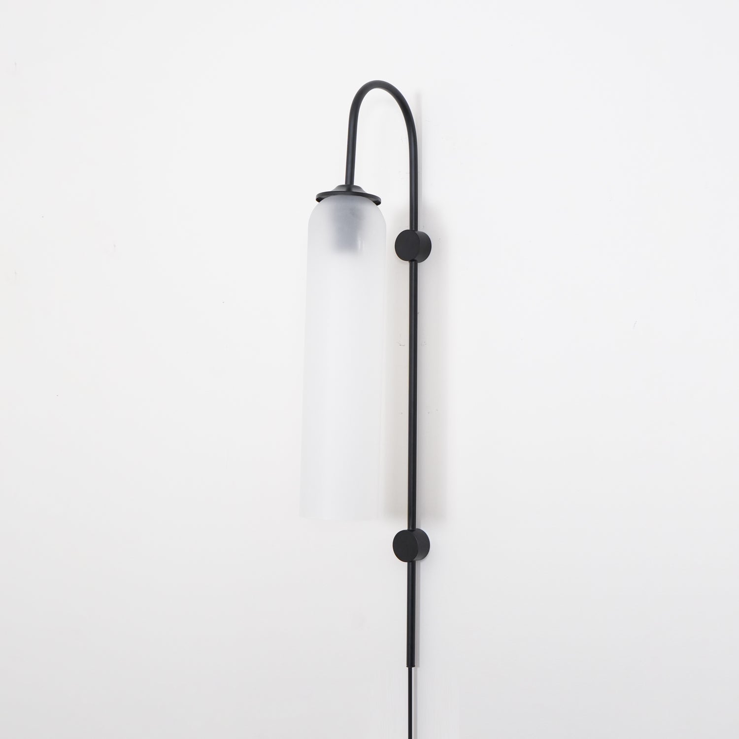 Clérachic mouth-blown glass wall sconce in frosted white on black, unlit, both disc mounts fixing the rod to the wall.