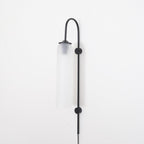 Clérachic mouth-blown glass wall sconce in frosted white on black, unlit, shot straight on against a white wall.