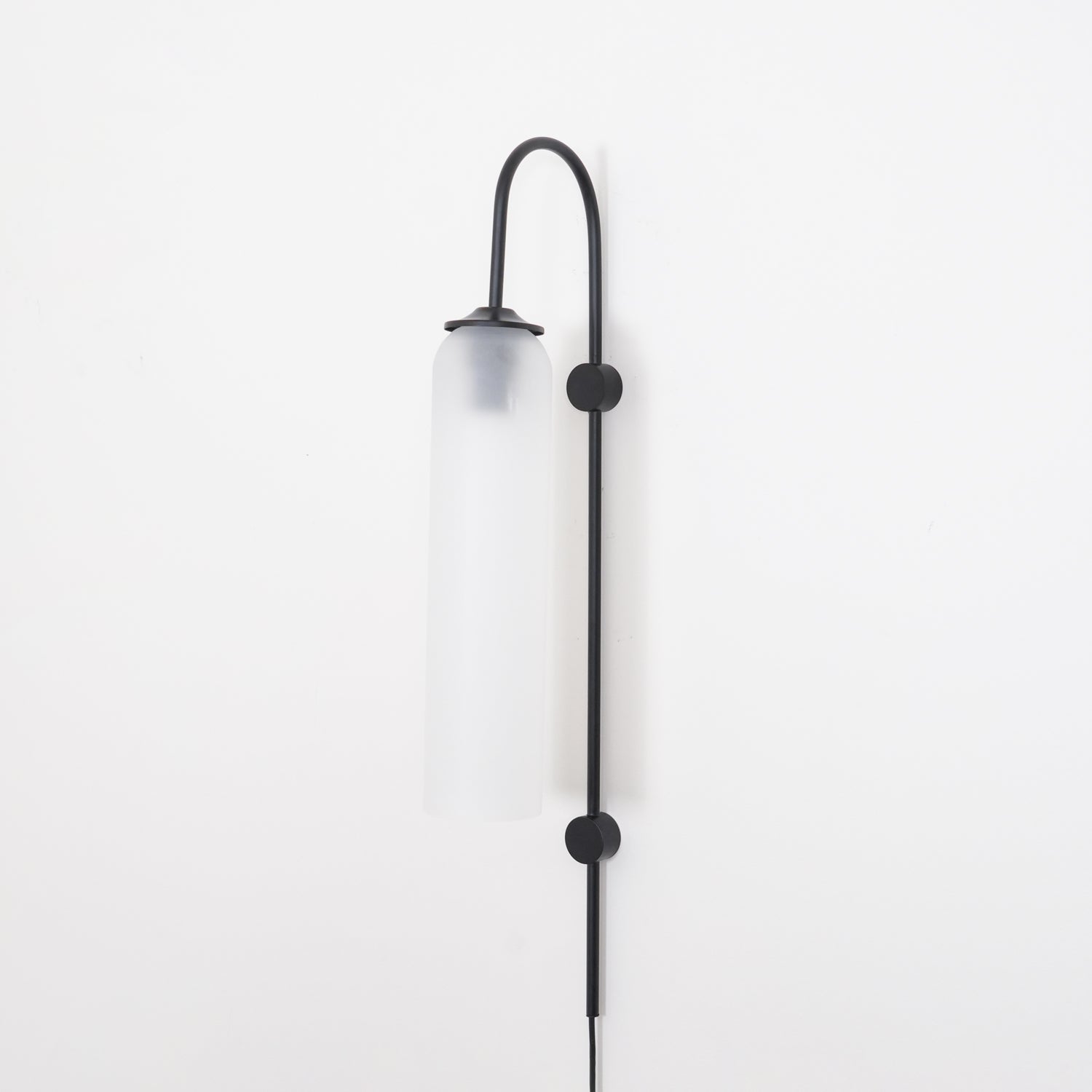 Clérachic mouth-blown glass wall sconce in frosted white on black, unlit, shot straight on against a white wall.
