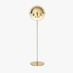 The Clérachic floor lamp in Brass, shown full length on plain white with its cord running from the round weighted base.