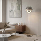 In a pale room beside a low sideboard, the polished Clérachic floor lamp in Chrome stands at reading height.