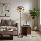 Set beside a sofa with a potted fig and framed art, this Clérachic floor lamp in Chrome needs no side table of its own.