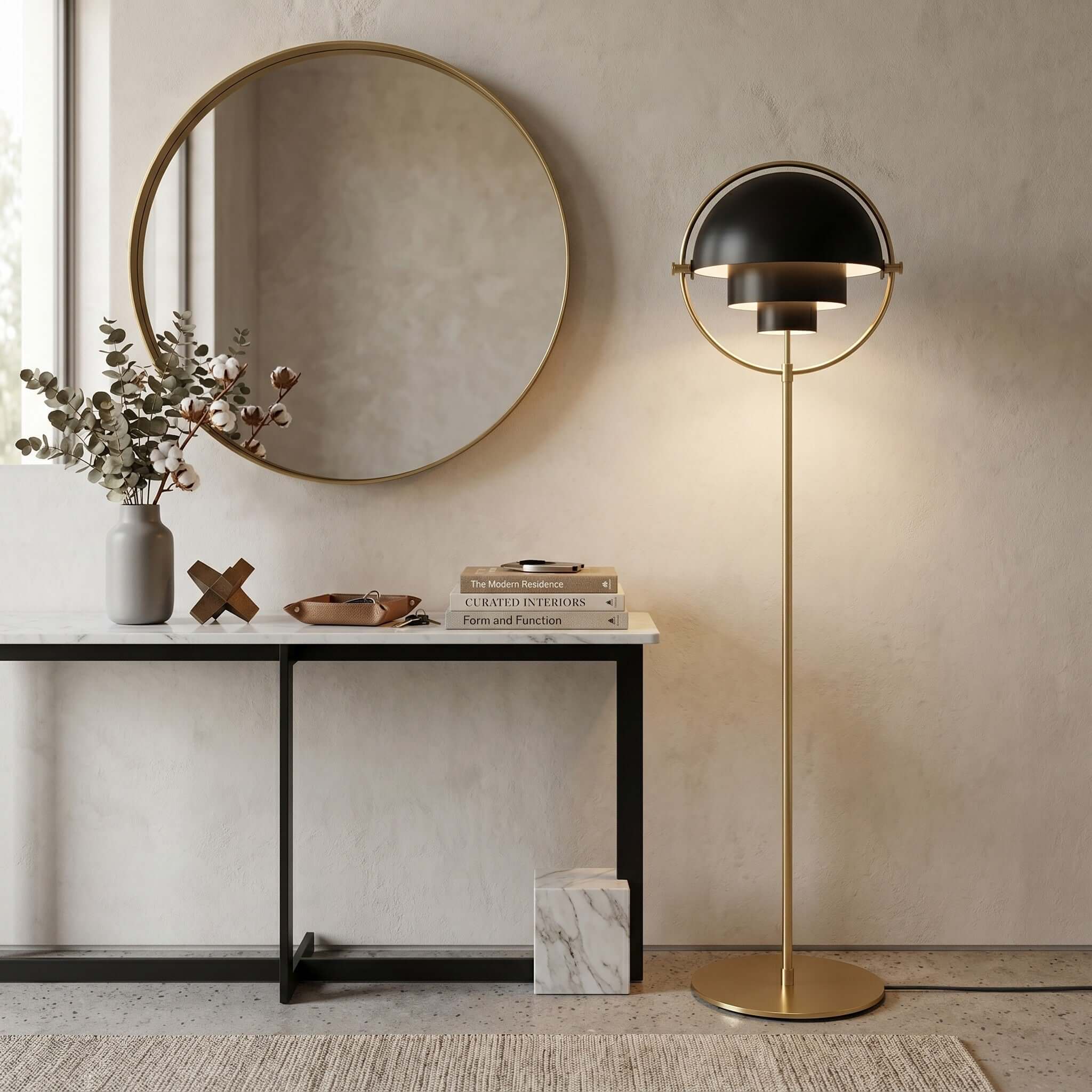 Under a round mirror and beside a console table, the Clérachic floor lamp in Black & Brass adds height to the corner.