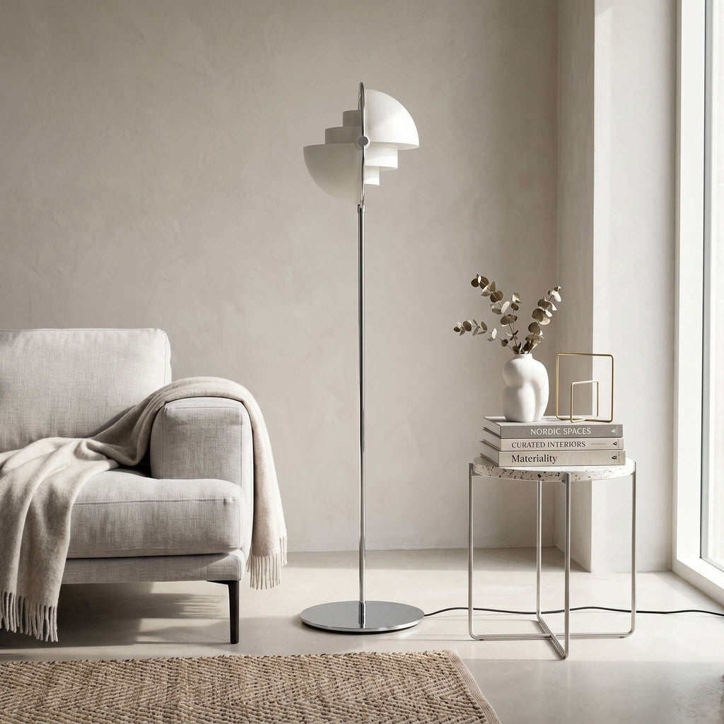 Next to a cream armchair and a small side table, this Clérachic floor lamp in White & Chrome stands on its own slim stem.