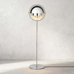 Photographed head-on against a pale wall, the Clérachic floor lamp in Chrome is polished from shades to base.