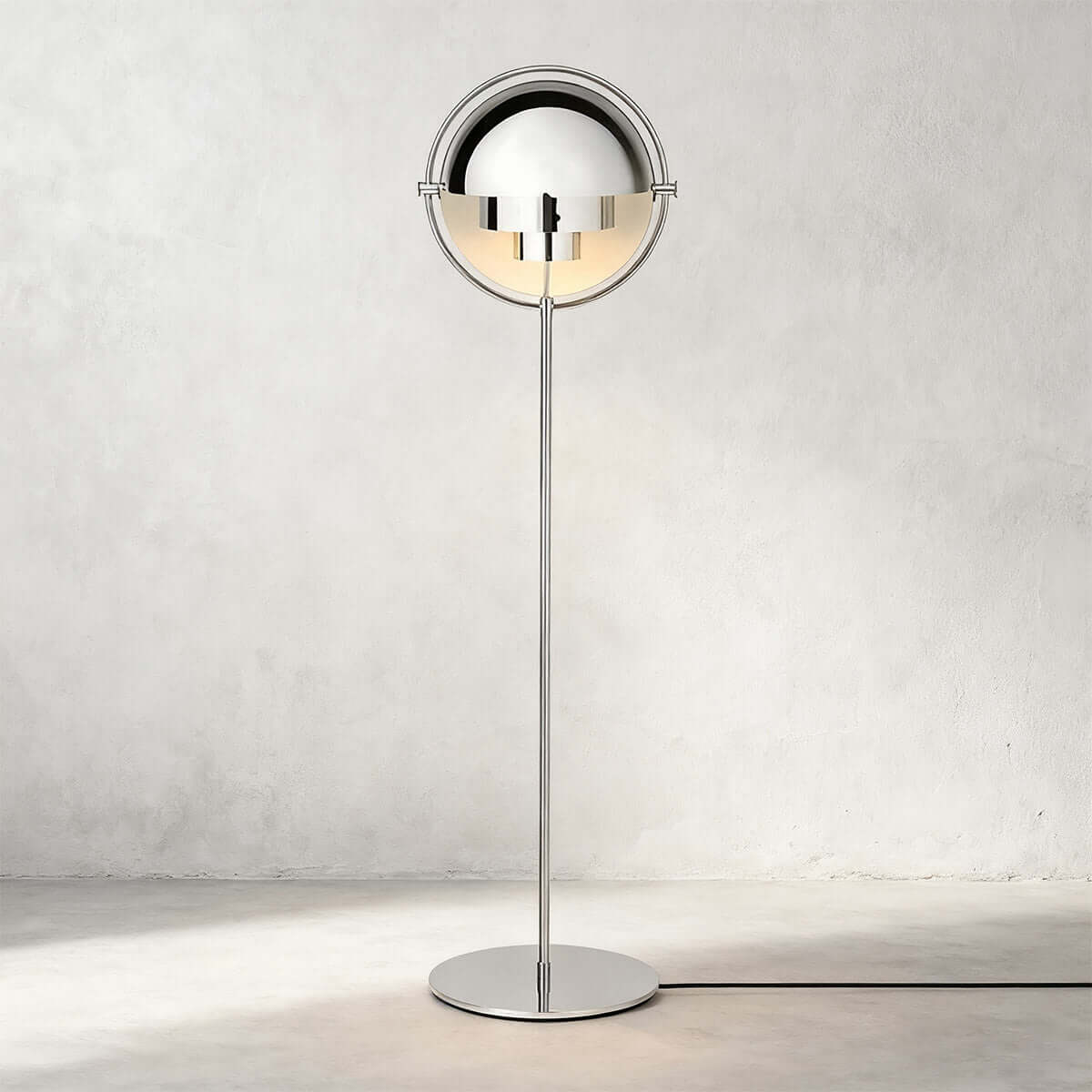 Photographed head-on against a pale wall, the Clérachic floor lamp in Chrome is polished from shades to base.