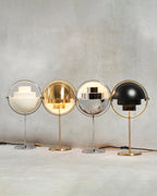 Four lit Clérachic table lamps lined up together — White & Chrome, Brass, Chrome and Black & Brass — showing how each finish handles the light.