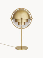 With both quarter-sphere shades rotated closed, the Clérachic table lamp in Brass hoods the inner cylinders so light is aimed down onto the surface.
