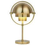 Clérachic table lamp in brushed brass throughout, lit from within so the inner cylinder glows warm.