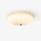 Clérachic Murano-Style Scalloped Glass Flush Ceiling Light in beige, lit from within so the petals turn honey rather than pooling light.