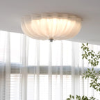 The Clérachic Murano-Style Scalloped Glass Flush Ceiling Light lit in a sunlit living room, with sheer curtains and a trailing plant below.