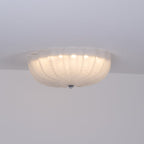 Side view of the lit Clérachic Murano-Style Scalloped Glass Flush Ceiling Light, dropping only a hand's depth below the ceiling line.