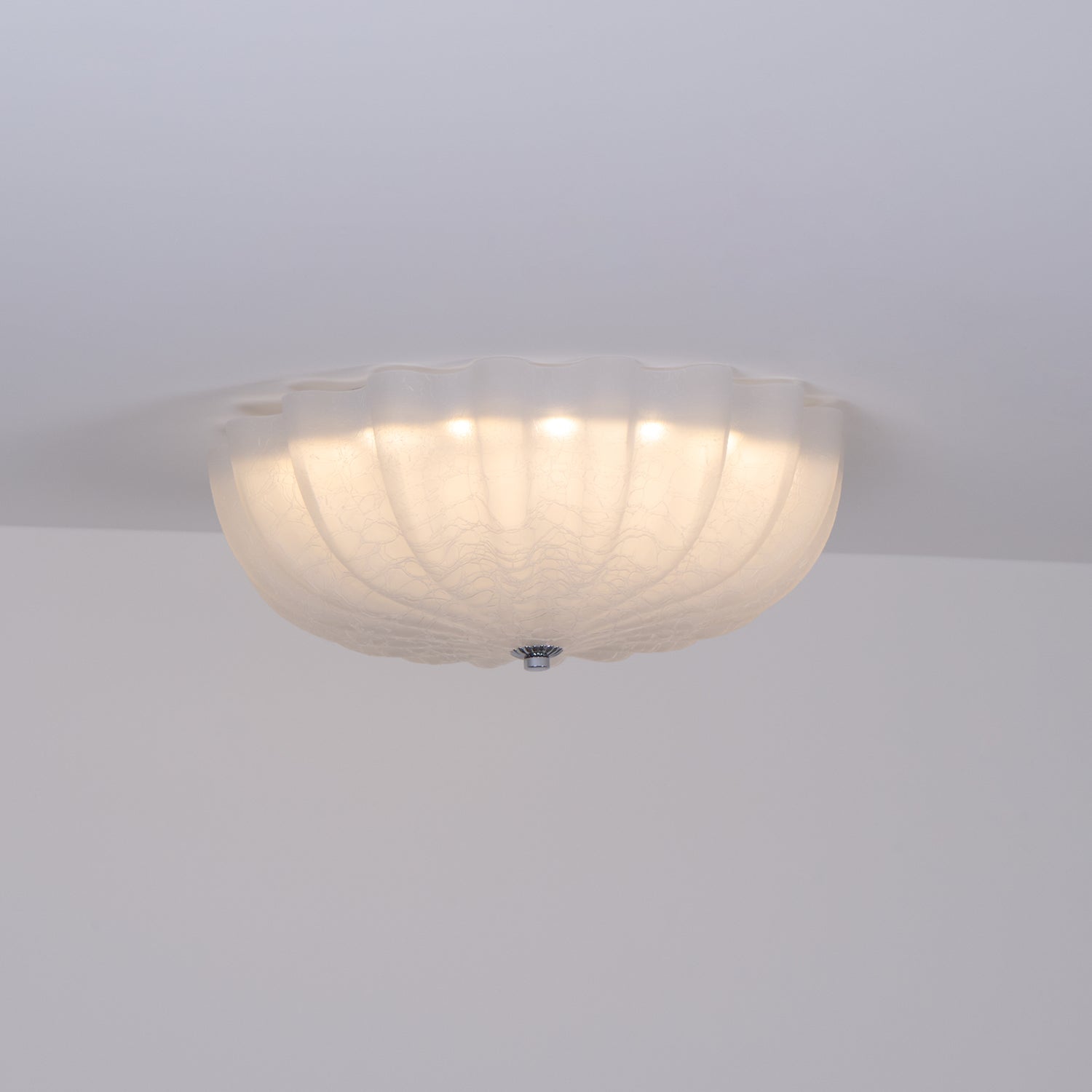 Side view of the lit Clérachic Murano-Style Scalloped Glass Flush Ceiling Light, dropping only a hand's depth below the ceiling line.