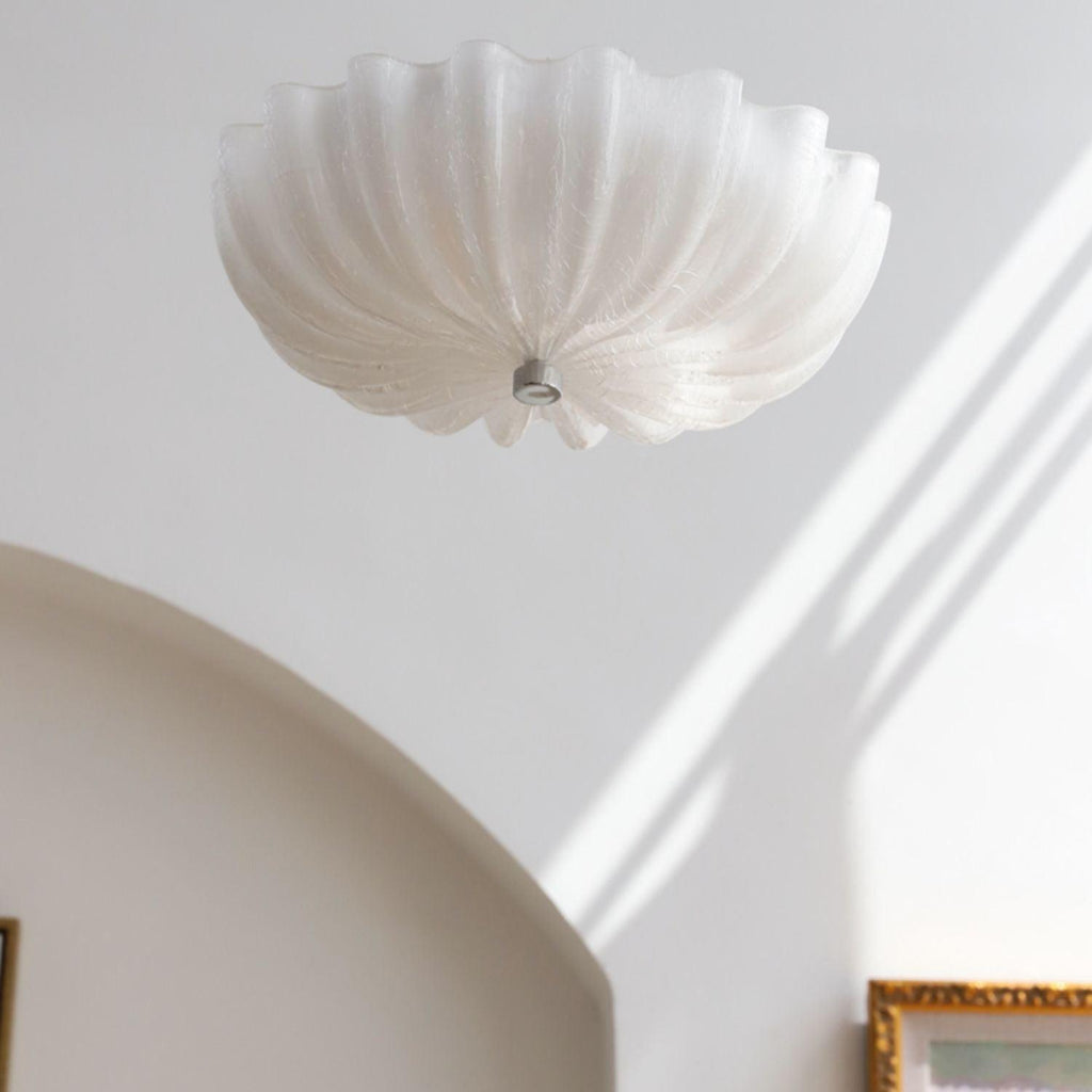 Clérachic Murano-Style Scalloped Glass Flush Ceiling Light unlit above an arched doorway, daylight raking the wall by a gilt-framed painting.