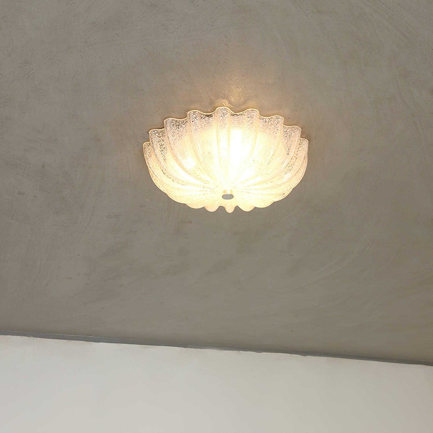 Clérachic Murano-Style Scalloped Glass Flush Ceiling Light lit against a raw limewashed plaster ceiling in a pared-back room.
