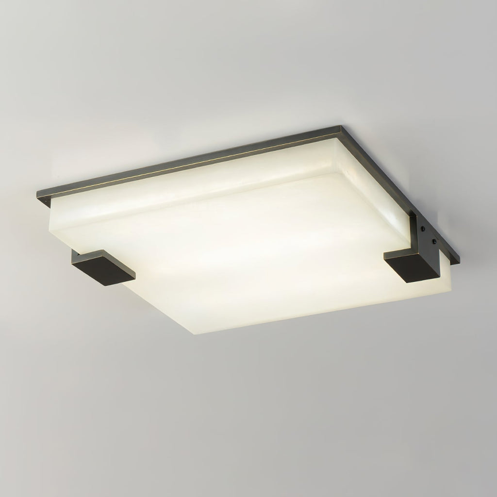 Clérachic flush mount lit from within, the alabaster diffuser catching a soft gradient of warm light across its face.
