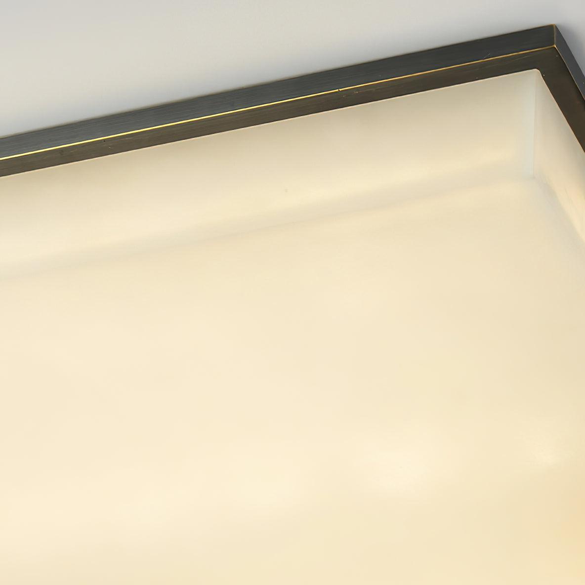 The Clérachic diffuser in close-up, a fine brass line running along the frame edge above the warm stone face.