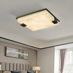 The Clérachic flush mount above a bedroom, veined alabaster glowing softly beside a framed landscape print.