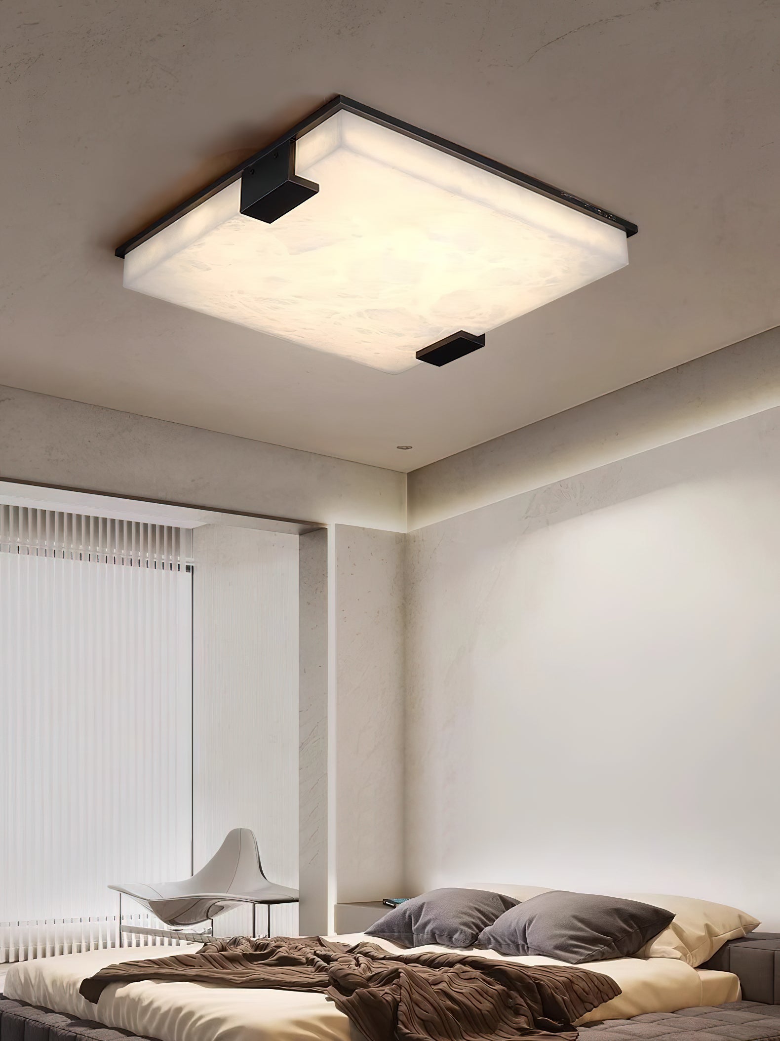 Clérachic flush mount in a bright bedroom corner, light pooling down the plaster wall beside sheer window blinds.