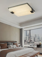 Clérachic flush mount viewed from the bed below, the pale alabaster panel steady against a floor-to-ceiling city view.