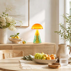 A Clérachic mushroom lamp on a rattan-front sideboard, with white flowers in a ribbed vase and a bowl of lemons.