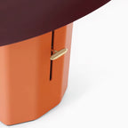 Close view of the slim brass switch lever set in the slot of the orange column on this Clérachic table lamp.