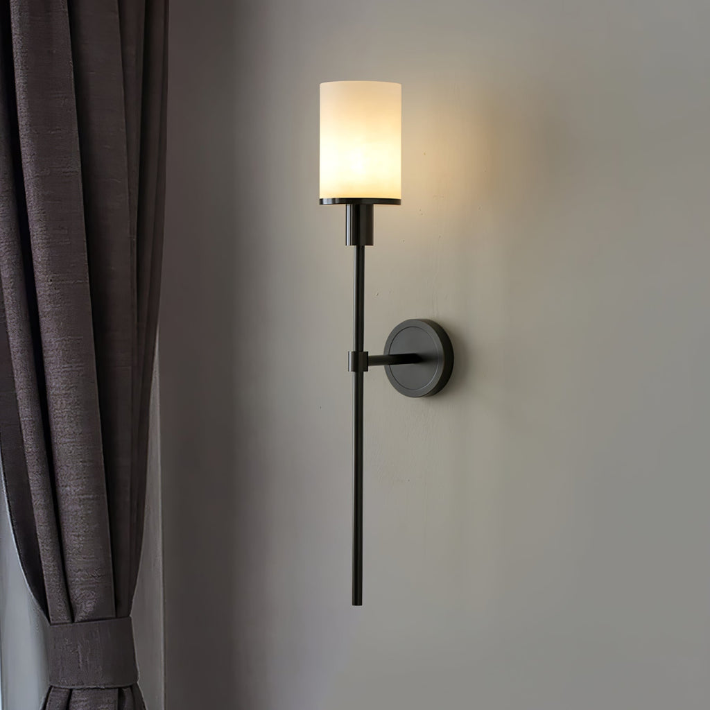 The Clérachic Mycara in black, mounted beside a pleated grey curtain with the glass shade glowing softly.