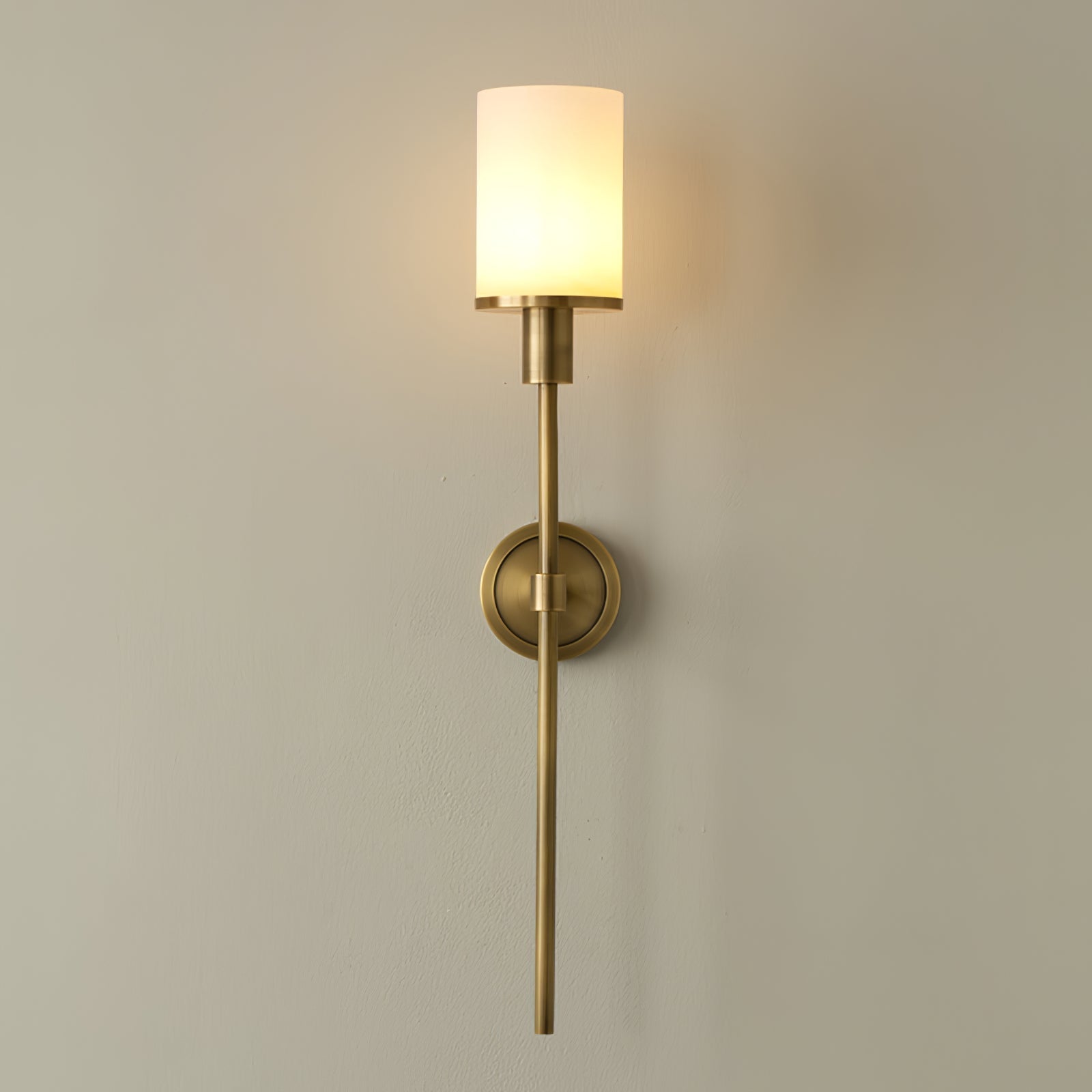 Clérachic Mycara in copper, the glass cylinder lit and the stem tapering to a fine point down the wall.