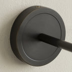 Close view of the Clérachic Mycara's black round backplate, showing the arm joint and top fixing screw.