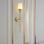 The Clérachic Mycara with alabaster shade on a white panelled wall traced with slim copper trim lines.